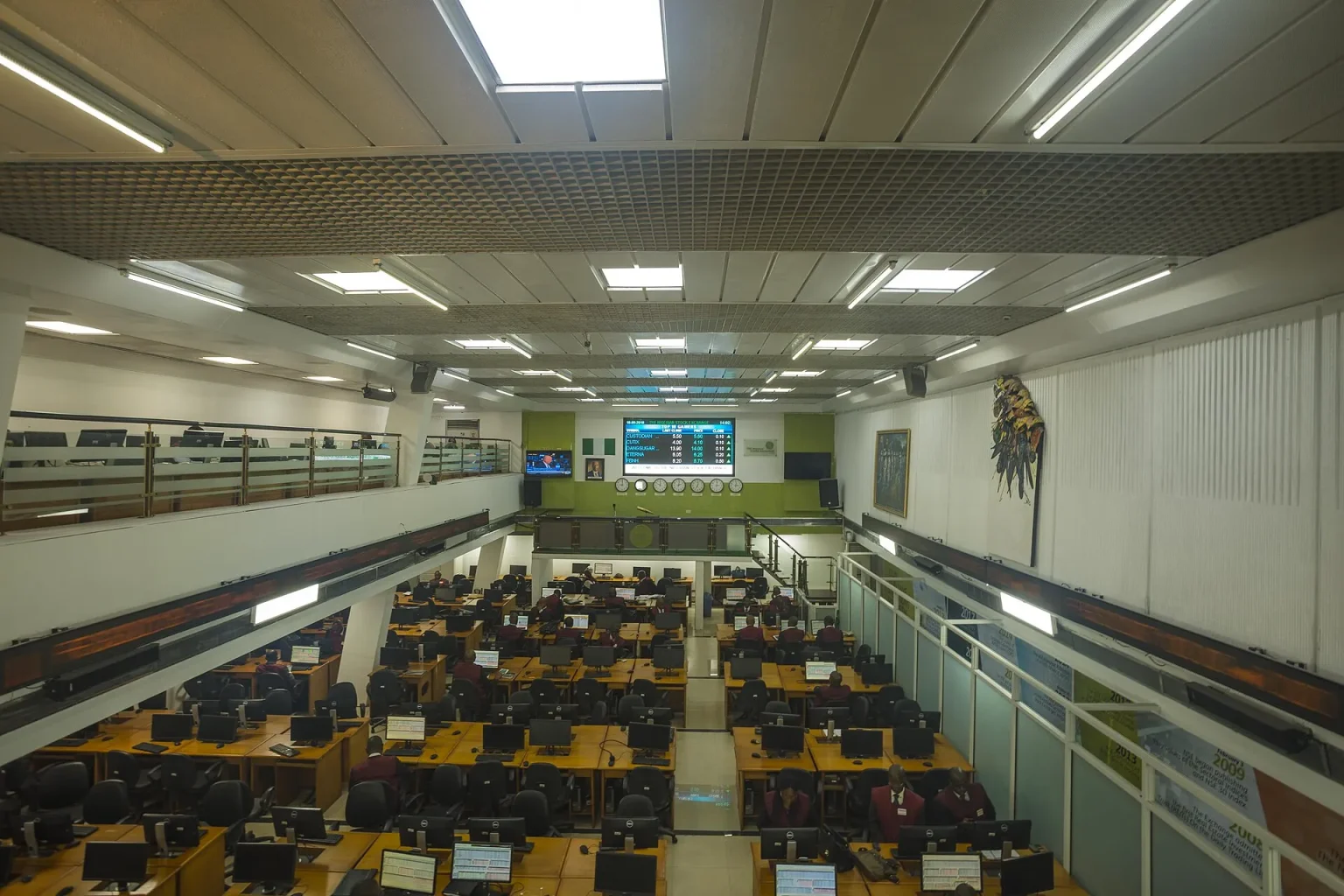 Busy stock exchange trading floor with rows of screens