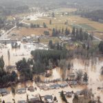 Aerial view of a flooded town with homes surrounded by water