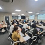 Students learning in a phone-free classroom with smartphones put away, illustrating a study on classroom bans and academic performance